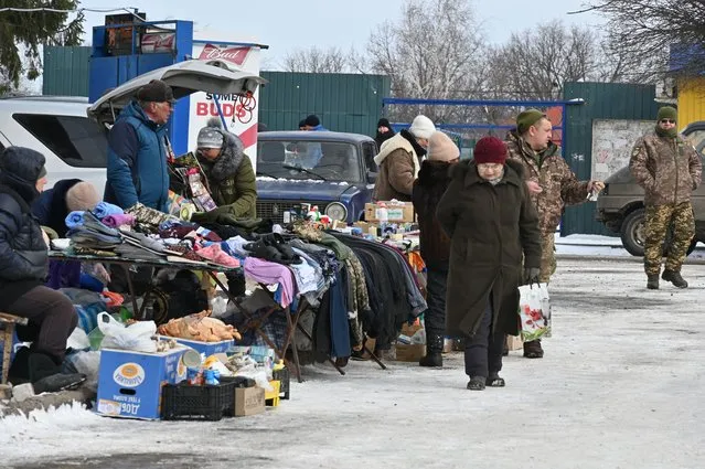 A local resident walks along an open-air market in Kupiansk, Kharkiv region, on February 13, 2023. (Photo by Sergey Bobok/AFP Photo)