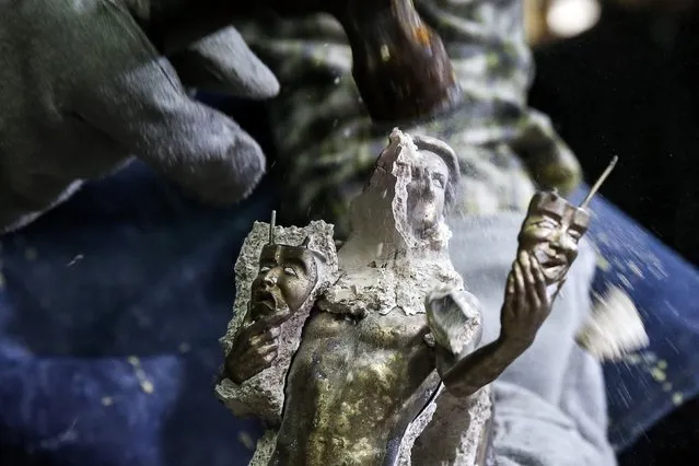 A worker uses a hammer to remove the mold, exposing the bronze statuette inside during a media event on the production of “The Actor” statuette for the 21th annual Screen Actors Guild (SAG) Awards at American Fine Arts Foundry in Burbank, California January 13, 2015. (Photo by Patrick T. Fallon/Reuters)