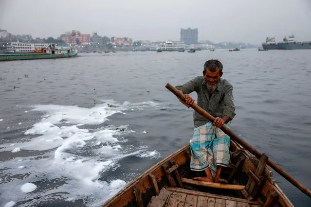 White foam is formed in the water as ferryman Abdul Karim, 72, rides his boat in the Buriganga river near the Sadarghat area in Dhaka, Bangladesh, March 27, 2023. (Photo by Mohammad Ponir Hossain/Reuters)