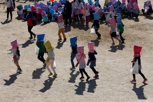 School children wearing padded hoods to protect them from falling debris take part in a tsunami simulation drill ahead of World Tsunami Awareness Day at Futaba elementary school in Choshi, Chiba Prefecture, Japan, November 4, 2016. (Photo by Kim Kyung-Hoon/Reuters)
