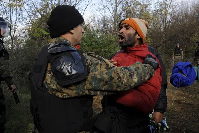 A stranded migrant argues with a Macedonian police officer as he tries to cross the Greek-Macedonian border, near the village of Idomeni, Greece  December 2, 2015. Picture taken from the Greek side of the border. (Photo by Alexandros Avramidis/Reuters)