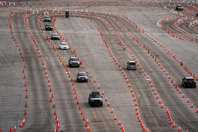 Traffic cones guide drivers into a mega COVID-19 vaccination site set up in the parking lot of Dodger Stadium in Los Angeles, Wednesday, January 27, 2021. California is changing up the way it is delivering coronavirus vaccines, moving to a more centralized system that is expected to streamline appointment sign-up, notification, and eligibility for nearly 40 million residents who want to know when they can get a shot and where. (Photo by Jae C. Hong/AP Photo)