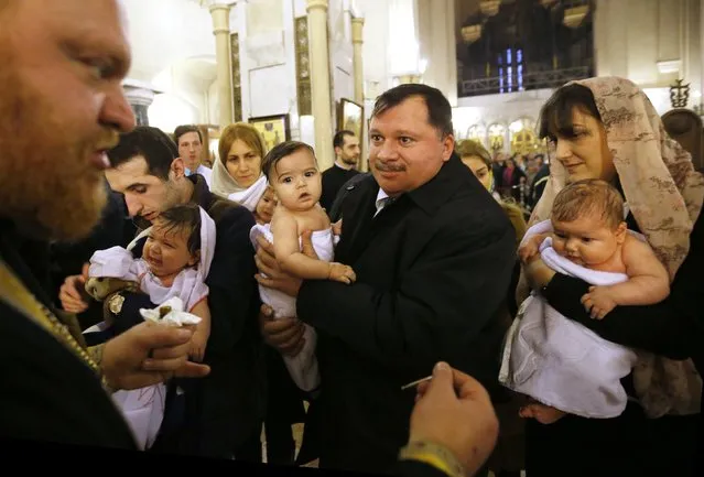 Babies are baptised during a mass baptism ceremony on Epiphany day in Tbilisi, January 19, 2015. (Photo by David Mdzinarishvili/Reuters)