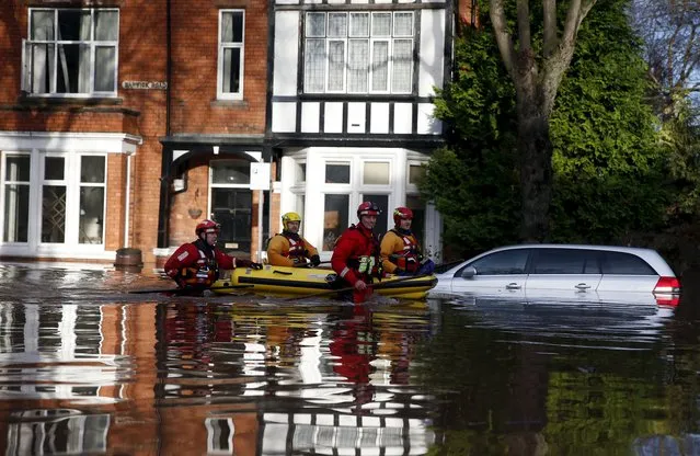 Rescue workers pull a boat along a flooded residential street in Carlisle, Britain December 6, 2015. (Photo by Phil Noble/Reuters)