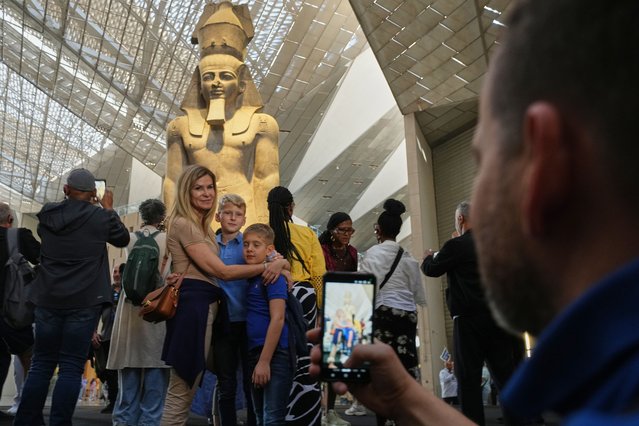 Tourists pose for a photo in front of the statue of Pharaoh Ramses II, during the first day for visitors after the official opening of the Grand Egyptian Museum in Giza, Egypt, Tuesday, November 4, 2025. (Photo by Amr Nabil/AP Photo)