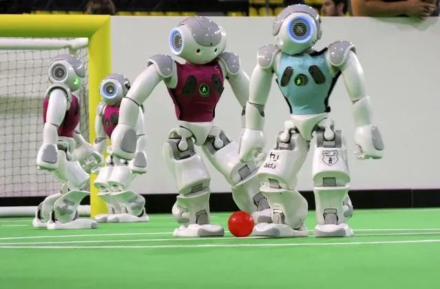 In this photo taken Thursday, June 27, 2013 robots in the “standard platform” division compete at the RoboCup championships in Eindhoven, Netherlands. Around 300 teams from 40 countries are competing this week in the RoboCup championships. The competition has the long-term goal of building a team of androids good enough to beat the human world cup team by 2050. (Photo by Toby Sterling/AP Photo)