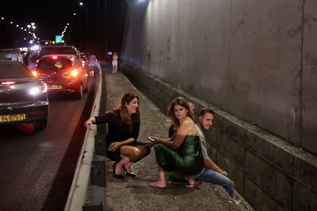 People take shelter during an air raid siren after Iran fired a salvo of ballistic missiles, amid cross-border hostilities between Hezbollah and Israel, in central Israel on October 1, 2024. (Photo by Ronen Zvulun/Reuters)
