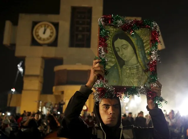 A pilgrim holds up an image of the Virgin of Guadalupe inside the Basilica of Guadalupe during the annual pilgrimage in honor of the Virgin of Guadalupe, patron saint of Mexican Catholics, in Mexico City, Mexico December 12, 2015. (Photo by Henry Romero/Reuters)