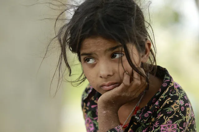 An Indian girl rests after being moved to a safer area following cross-border firing in Ranbir Singh Pura district of Jammu and Kashmir state, India, Tuesday, May 22, 2018. Villages along the India-Pakistan international border are almost deserted as most have moved to safer areas away from the volatile border region. (Photo by Channi Anand/AP Photo)