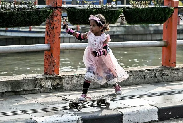 A girl rides her skateboard during a gathering to mark the “Go Skateboarding Day” in Surabaya on June 21, 2023. (Photo by Juni Kriswanto/AFP Photo)