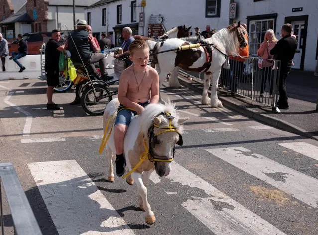 A boy rides his horse along the road during the annual horse fair in Appleby-in-Westmorland, Britain on June 8, 2023. (Photo by Phil Noble/Reuters)