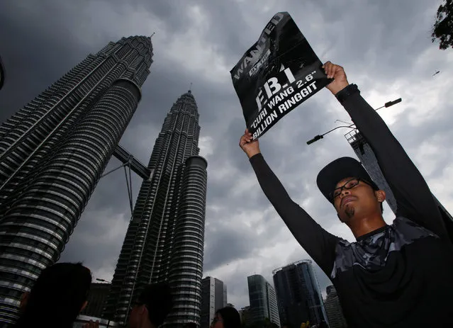 A man holds up a poster during a 1MDB protest organized by Pro-democracy group Bersih, calling for Malaysian Prime Minister Najib Abdul Razak to resign, in Kuala Lumpur, Malaysia November 19, 2016. (Photo by Edgar Su/Reuters)