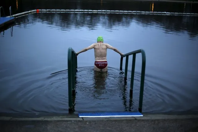 A swimmer takes a dip in the Serpentine River before the annual Christmas Day Peter Pan Cup handicap race in Hyde Park, London, December 25, 2015. (Photo by Andrew Winning/Reuters)