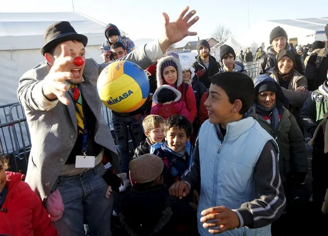 A member of Red Noses Clowndoctors entertains migrants before their departure to Austria at a registration center in Dobova, Slovenia, December 27, 2015. (Photo by Srdjan Zivulovic/Reuters)
