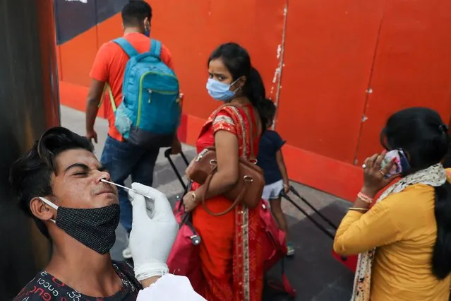 A man reacts as a healthcare worker collects a swab sample, amidst the spread of the coronavirus disease (COVID-19), at a railway station, in New Delhi, India, April 7, 2021. (Photo by Anushree Fadnavis/Reuters)