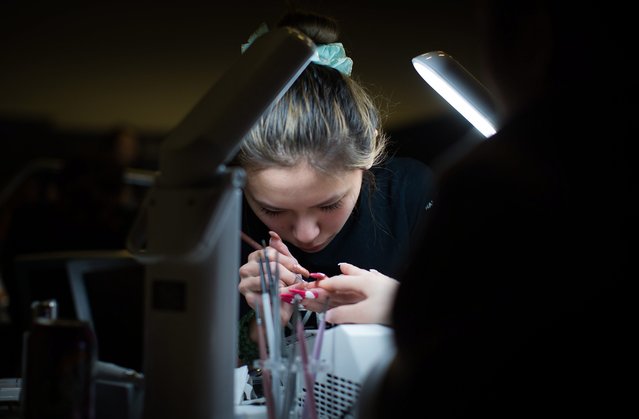 Competitor Cindy Yuen works on the nails of a model at the Canada Nail Cup in Vancouver, Monday, February 16, 2015. (Photo by Darryl Dyck/AP Photo/The Canadian Press)