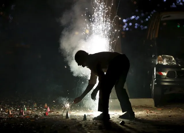 A man lights firecrackers on the street during the New Year celebrations in Mumbai, India, January 1, 2016. (Photo by Danish Siddiqui/Reuters)