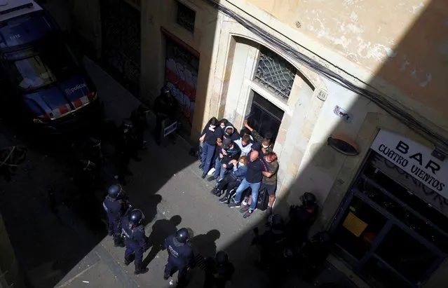 Activists are surrounded by police as they protest against the eviction of a family from their home in El Raval neighbourhood, amid the coronavirus disease (COVID-19) pandemic in Barcelona, Spain, May 12, 2021. (Photo by Nacho Doce/Reuters)