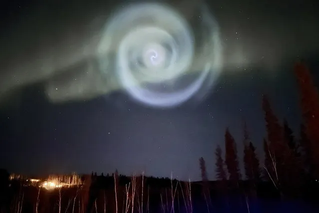 In this photo provided by Christopher Hayden, a light baby blue spiral resembling a galaxy appears amid the aurora for a few minutes in the Alaska skies near Fairbanks, Saturday, April 15, 2023. The spiral was formed when excess fuel that had been released from a SpaceX rocket that launched from California about three hours earlier turned to ice, and then the water vapor reflected the sunlight in the upper atmosphere. (Photo by Christopher Hayden via AP Photo)