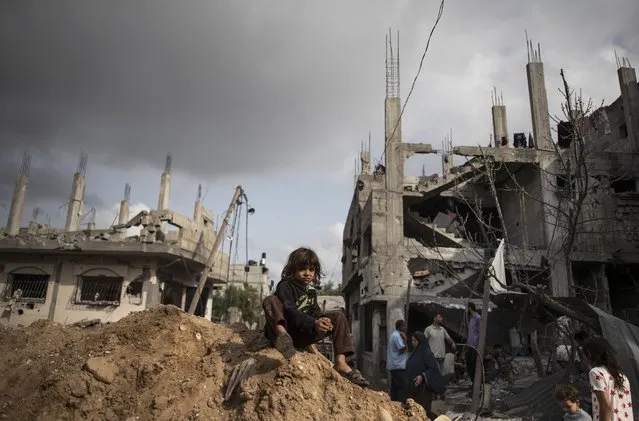 Palestinians inspect the damage of their destroyed homes after returning following a cease-fire reached after an 11-day war between Gaza's Hamas rulers and Israel, in town of Beit Hanoun, northern Gaza Strip, Friday, May 21, 2021. (Photo by Khalil Hamra/AP Photo)