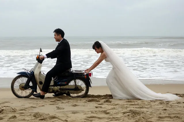 A Vietnamese bride is seen pushing the groom on a scooter during a photo shoot for their wedding in An Bang Beach outside Hoi An in Vietnam December 11, 2016. (Photo by Reuters/Stringer)