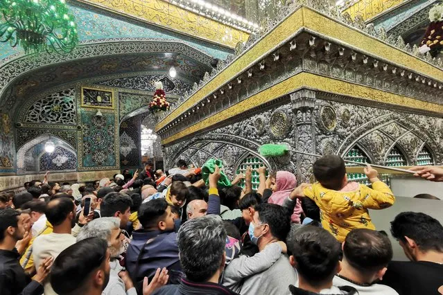 Pilgrims touch the holy shrine of Imam Reza in the city of Mashhad, the capital of the province of Khorassan-e Razavi in northeastern Iran, on October 1, 2023. (Photo by Atta Kenare/AFP Photo)