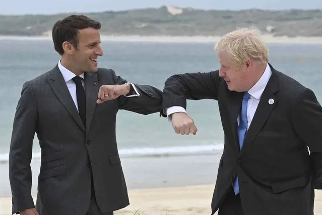 Britain's Prime Minister Boris Johnson, right greets French President Emmanuel Macron prior to the Leaders official welcome and group photo session, during the G7 summit, in Carbis Bay, Cornwall, England, Friday, June 11, 2021. (Photo by Leon Neal/Pool Photo via AP Photo)