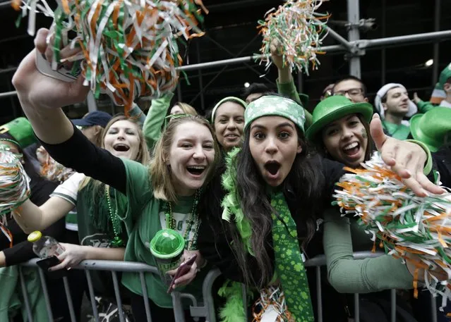 People cheer as participants march up Fifth Avenue during the St. Patrick's Day Parade, Tuesday, March 17, 2015, in New York. (Photo by Mary Altaffer/AP Photo)