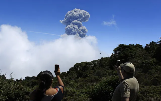 People take pictures of an eruption of the Turrialba volcano, from San Gerardo de Irazu near Turrialba, March 13, 2015. Costa Rica's Turrialba volcano belched a column of gas and ash up to 3,280 feet (1 km) into the air on Thursday in its most powerful eruption in two decades, and local authorities started to evacuate residents from the surrounding area. (Photo by Juan Carlos Ulate/Reuters)