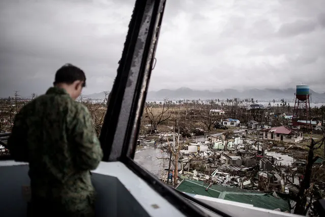 A Filipino military personnel stands in the damaged control tower of the airport in Tacloban, on the eastern island of Leyte on November 12, 2013 after Super Typhoon Haiyan swept over the Philippines. (Photo by Philippe Lopez/AFP Photo)