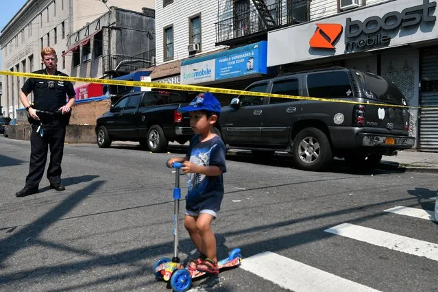 A child looks at an evidence marker near the scene of a shooting in the borough of Queens, New York, N.Y., U.S., July 6, 2021. (Photo by Lloyd Mitchell/Reuters)