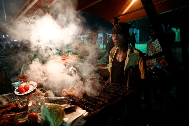 A man roasts meat popularly known as “Suya” outside the venue at One Lagos fiesta at the Bar beach in Victoria Island in Nigeria's commercial capital Lagos December 31, 2016. (Photo by Akintunde Akinleye/Reuters)