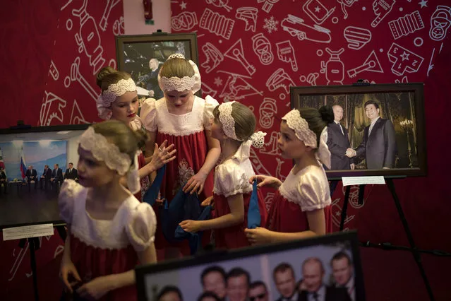 A group of girls stand next to photos of Russia's President Vladimir Putin during the opening of the Sports House, set up to support the Russian delegation of the 2018 Winter Olympics, in Gangneung, South Korea, Friday, February 9, 2018. (Photo by Felipe Dana/AP Photo)