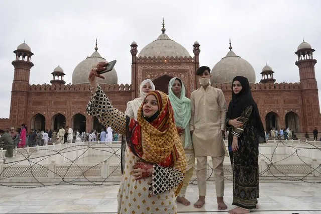 A woman takes a selfie with her friends after offering prayers at the historical Badshahi Mosque during the Eid al-Adha or the “Festival of Sacrifice”, in Lahore on July 21, 2021. (Photo by Arif Ali/AFP Photo)