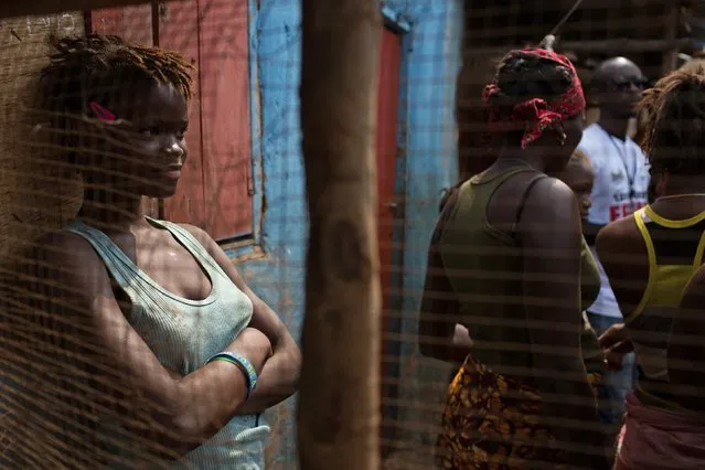 Social mobilizers speak with residents, including children during the three-day stay-at-home curfew in a slum in Freetown, Sierre Leone, in this UNICEF handout photo taken March 27, 2015. From 27 to 29 March 2015 in Sierra Leone, a government-led stay-at-home curfew was held as part of the four-week Zero Ebola campaign to end infections in the country. (Photo by Reuters/Bindra/UNICEF)