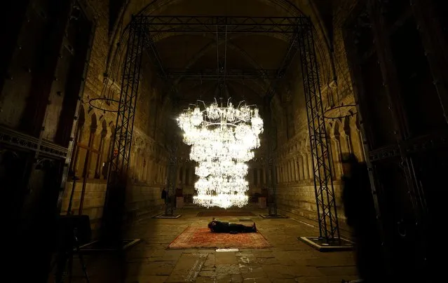 A photographer clicks pictures at Chinese artist Al Weiwel’s Illuminated Bottle Rack displayed in the Chapter House room of Durham Cathedral during the biennial Lumiere photocall in Durham, Britain on November 15, 2023. (Photo by Lee Smith/Reuters)