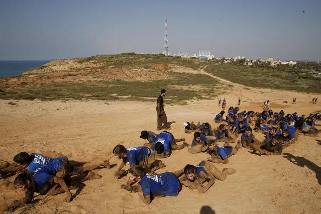 Israeli teenagers crawl as they participate in an annual combat fitness training competition, as part of their preparations ahead of their compulsory army service, near Kibbutz Yakum, central Israel February 19, 2016. (Photo by Baz Ratner/Reuters)