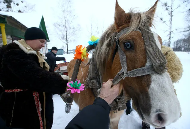 Men prepare a horse and a sleigh to celebrate the pagan rite called “Kolyadki” and mark the New Year, according to the Julian calendar on January 13, in the village of Vosava, Belarus January 13, 2017. (Photo by Vasily Fedosenko/Reuters)