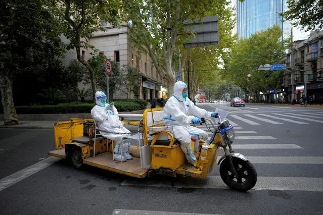 Medical workers in protective suits ride an electric tricycle on a street, following the coronavirus disease (COVID-19) outbreak in Shanghai, China on November 3, 2022. (Photo by Aly Song/Reuters)