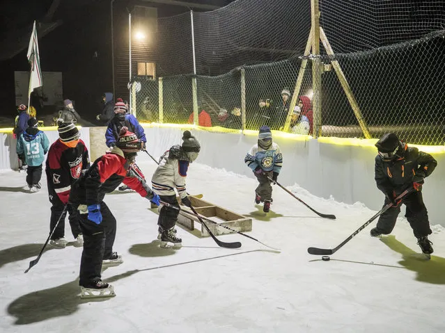 Hockey players chase the puck during an attempt at the Guinness Book of World Records record for coldest hockey game played Thursday,  January 31, 2019, in the backyard belonging to Mike Burman in northwest Rochester, Minn. About 25 kids took to the ice in the attempt. The air temperature, according to the National Weather Service, was in the high 20s below zero, and the wind chill was in the mid-40s below zero. (Photo by Joe Ahlquist/The Rochester Post-Bulletin via AP Photo)