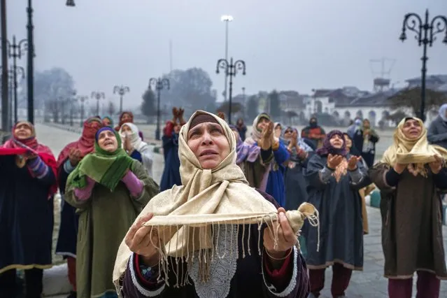Kashmiri Muslims raise their hands and pray as the head priest displays a relic believed to be a hair from the beard of the Prophet Mohammad during special prayers on the death anniversary of Abu Bakr Siddiq, the first Caliph of Islam, at Hazratbal Shrine in Srinagar, Indian controlled Kashmir, Friday, January 5, 2024. (Photo by Dar Yasin/AP Photo)