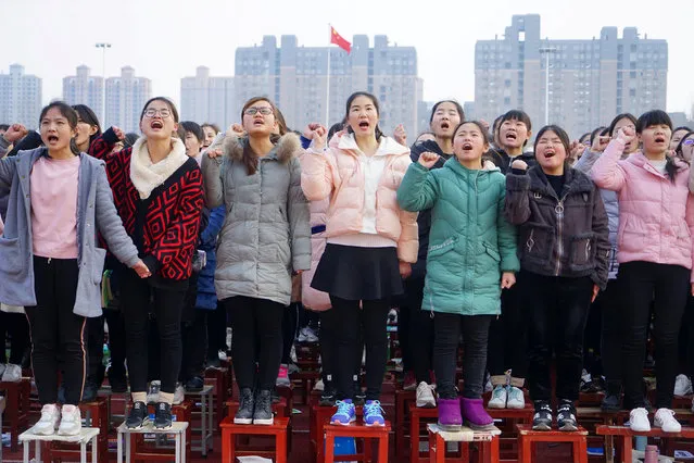 Students stand on chairs as they cheer at an oath-taking rally for the annual national entrance examinations, or “gaokao” in June, at a high school in Zhumadian, Henan province, China February 27, 2019. (Photo by Reuters/China Stringer Network)