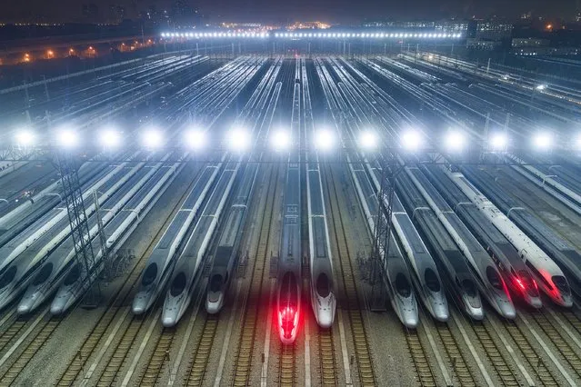High speed trains are lined up after undergoing maintenance in preparation for the annual Lunar New Year travel peak, at a maintenance base in Wuhan, in China's central Hubei province early on January 26, 2024. (Photo by AFP Photo/China Stringer Network)