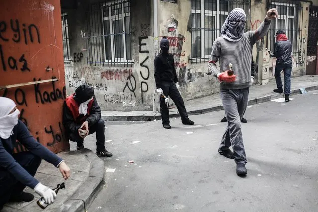 Protestors hold molotov cocktails during a May Day rally near Taksim Square in Istanbul on May 1, 2015. Turkish police put Istanbul under a security shutdown to thwart unauthorised demonstrations on a tense May Day, as tens of thousands of labour activists turned out worldwide to defend their rights at a time of austerity. (Photo by Yasin Akgul/AFP Photo)