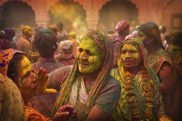Hindu widows apply colour powder to each other during Holi celebrations at the Gopinath temple, 180 kilometres (112 miles) south-east of New Delhi, India, Monday, March 21, 2016. (Photo by Manish Swarup/AP Photo)