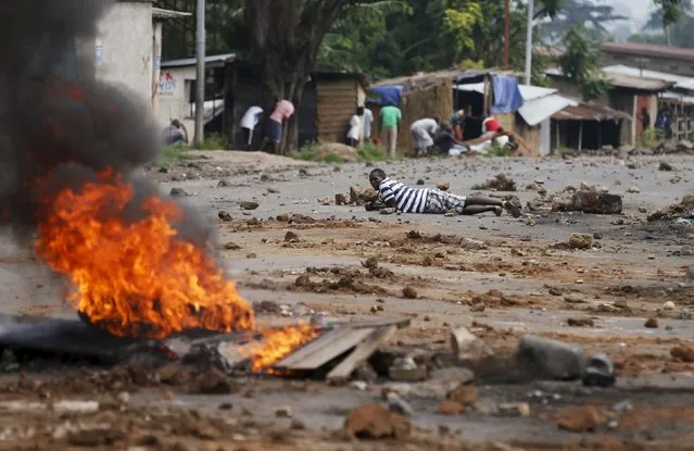 Demonstrators take cover during a protest against Burundi President Pierre Nkurunziza and his bid for a third term in Bujumbura, Burundi, May 20, 2015. (Photo by Goran Tomasevic/Reuters)