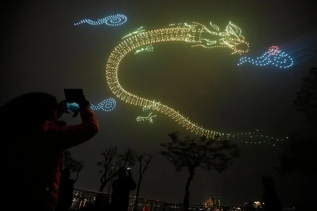 Drones light up the sky during a drone light show on Lunar New Year's Eve in Hanoi, Vietnam, 09 February 2024. Hanoi is expected to reach a Southeast Asian record with 2024 drones flying in the “Hanoi Light Festival – Brilliant Thang Long” event. The lunar new year, also called Tet, is the most significant celebration in Vietnamese culture and falls on 10 February this year, the year of the Dragon. (Photo by Luong Thai Linh/EPA/EFE)