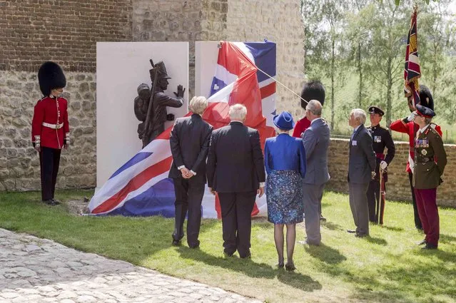 Britain's Prince Charles (4thL) holds a cord as he unveils a monument during a ceremony for the opening of the Hougoumont farm as part of the bicentennial celebrations for the Battle of Waterloo, near Waterloo, Belgium June 17, 2015. The commemorations for the 200th anniversary of the Battle of Waterloo will take place in Belgium on June 19 and 20. REUTERS/Geert Vanden Wijngaert/Pool