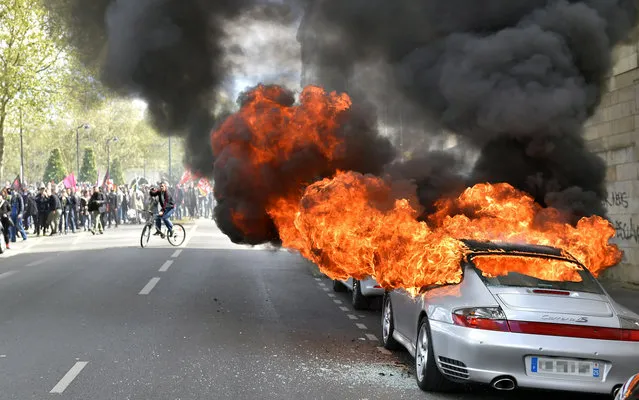 A car burns during a demonstration against the French government's proposed labour reforms on April 28, 2016 in Nantes. (Photo by Loic Venance/AFP Photo)