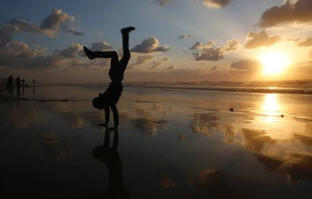 A Palestinian youth plays as the sun sets at the beach in Gaza City on March 29, 2016. (Photo by Mohammed Abed/AFP Photo)